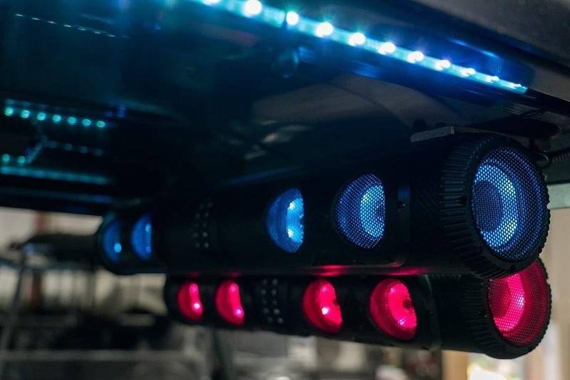 Glow lights and a Bluetooth speaker lit up under the roof of a Beach Better rental cart